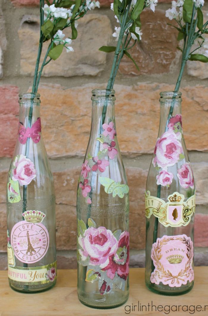 garrafa de vidro com flores coladas