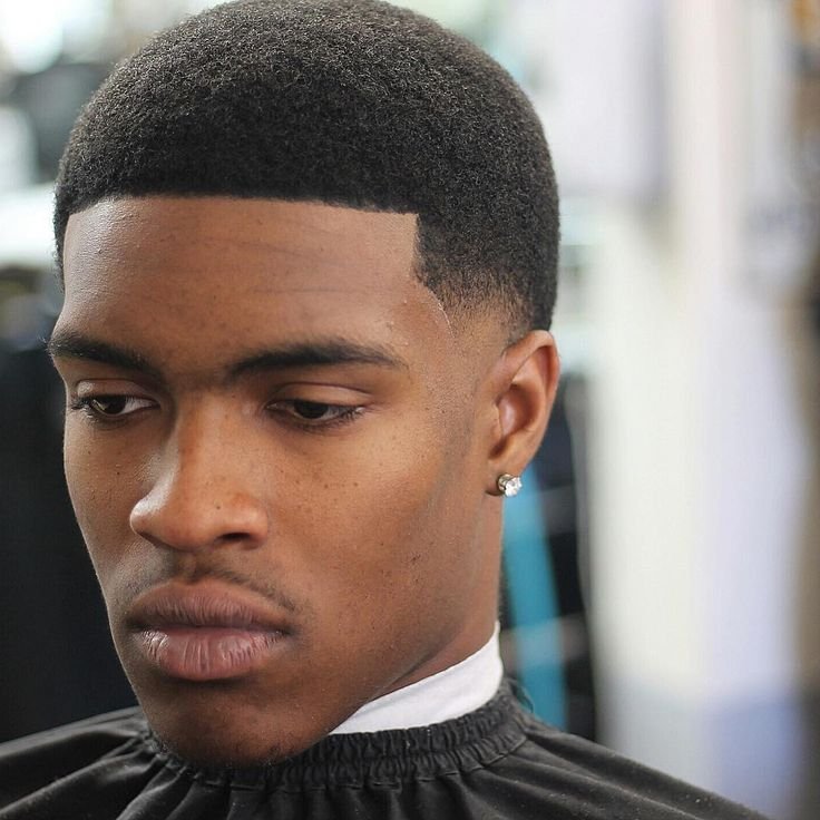 foto de homem negro no barbeiro com cabelo curto com desvanecimento baixo