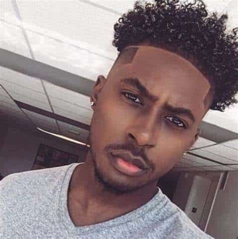 Cachos torcidos e parte cirúrgica corte de cabelo de homem negro
