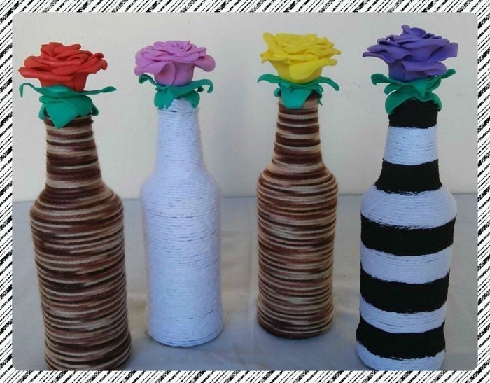 garrafa de vidro com linha e flor 